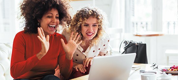 Two women smiling, looking at computer screen