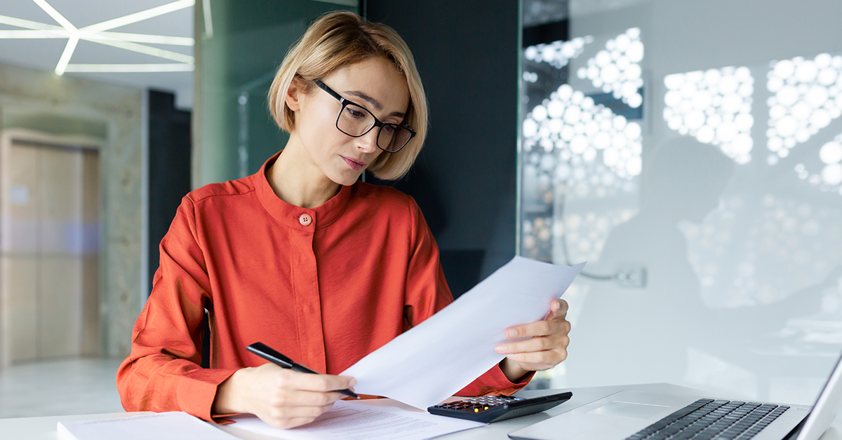 Pensive business woman behind paper work inside office