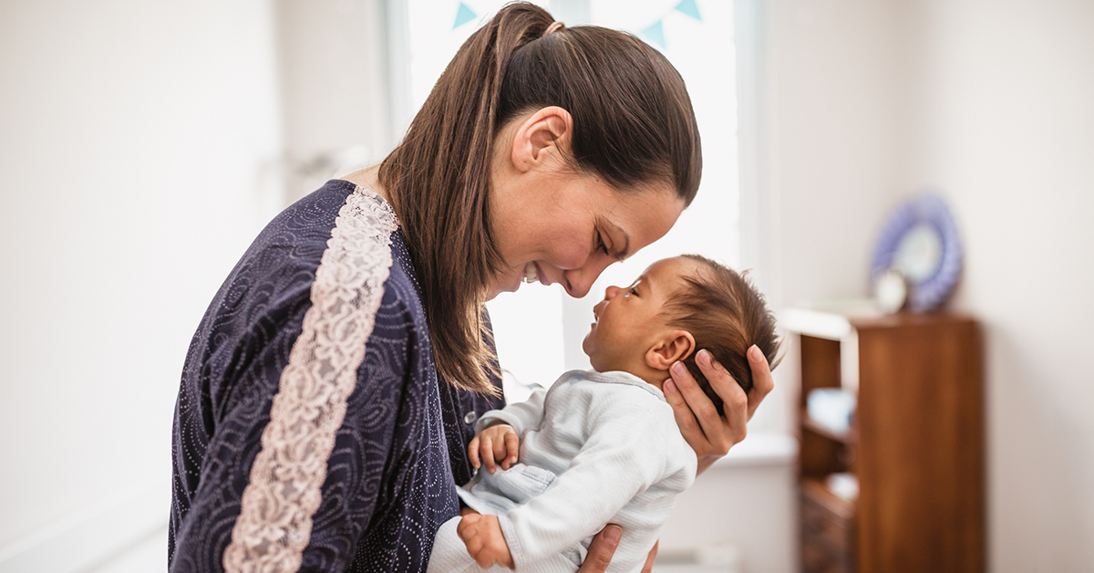 Mother cuddling with her newborn child in a bedroom