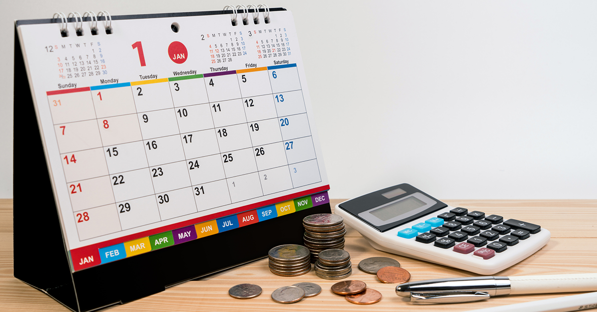 Money pen calculator and desk calendar on wooden table