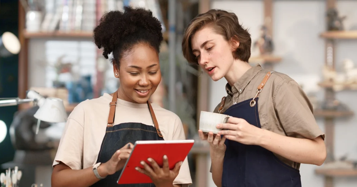 Coworkers reviewing tablet in a cafe