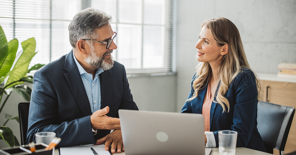 Man and woman in a business meeting, having a discussion in front of computer