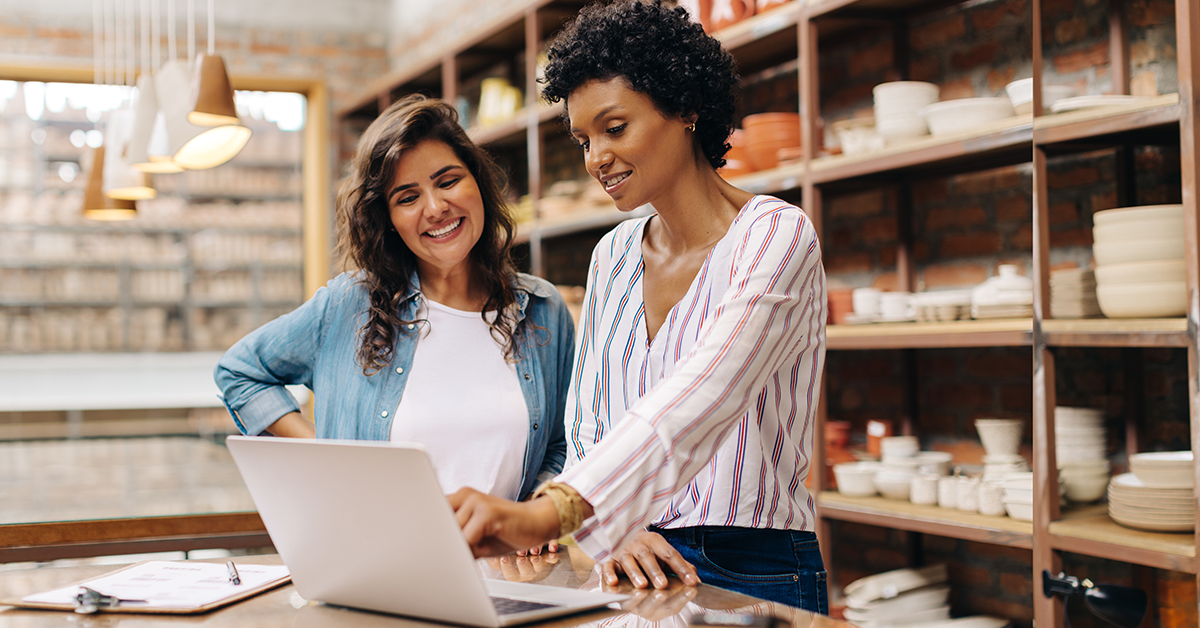 Two women working in a ceramic shop looking at laptop