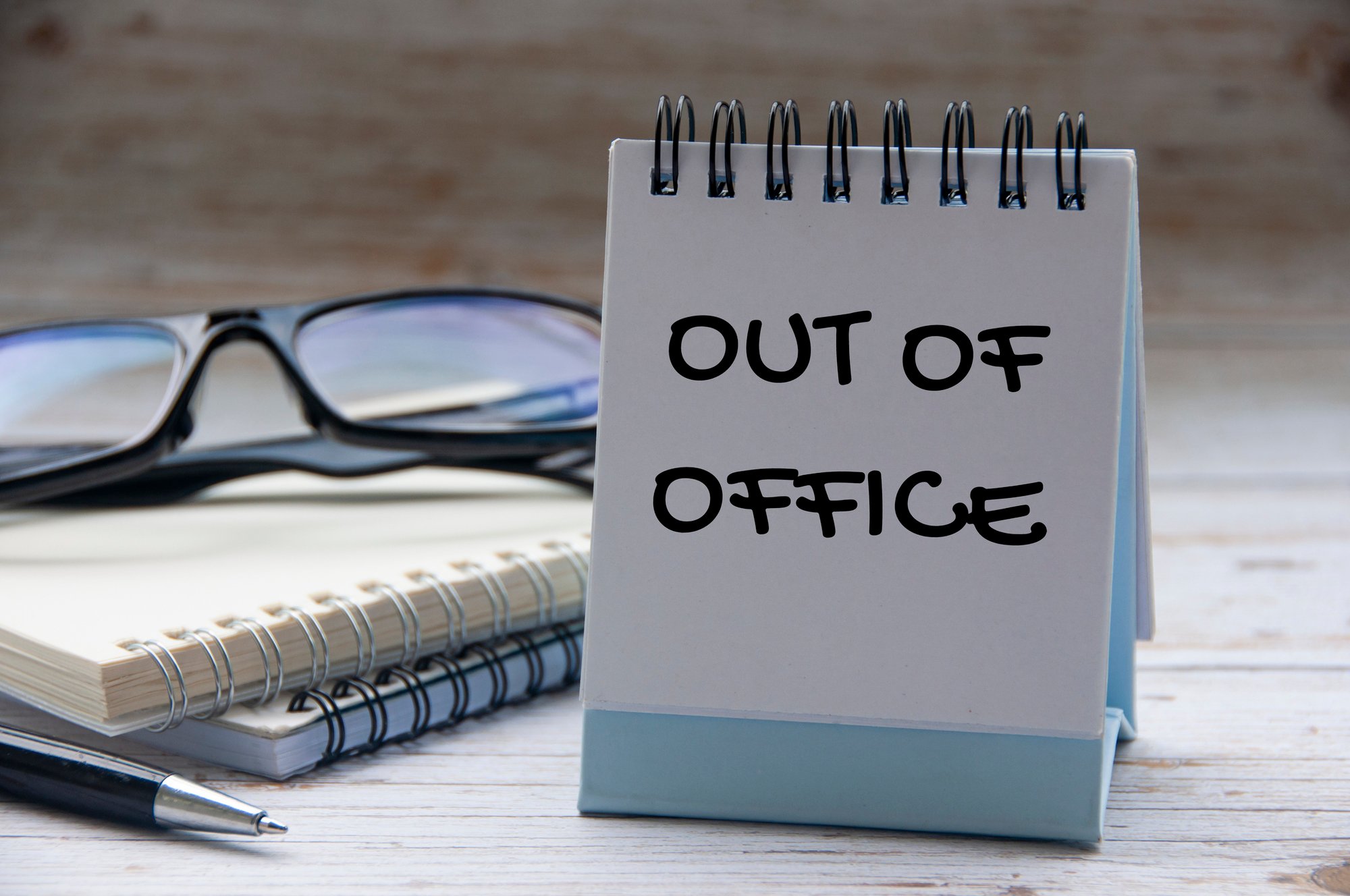An out of office sign on a desk.