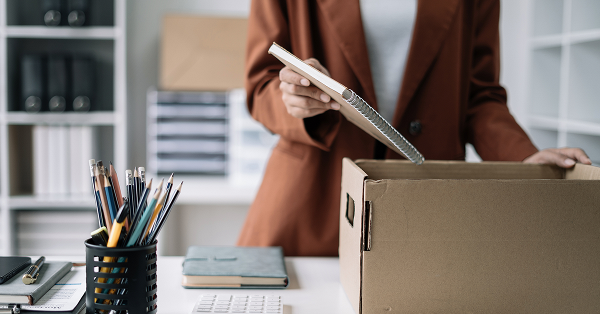 Businesswoman placing items in a box in office