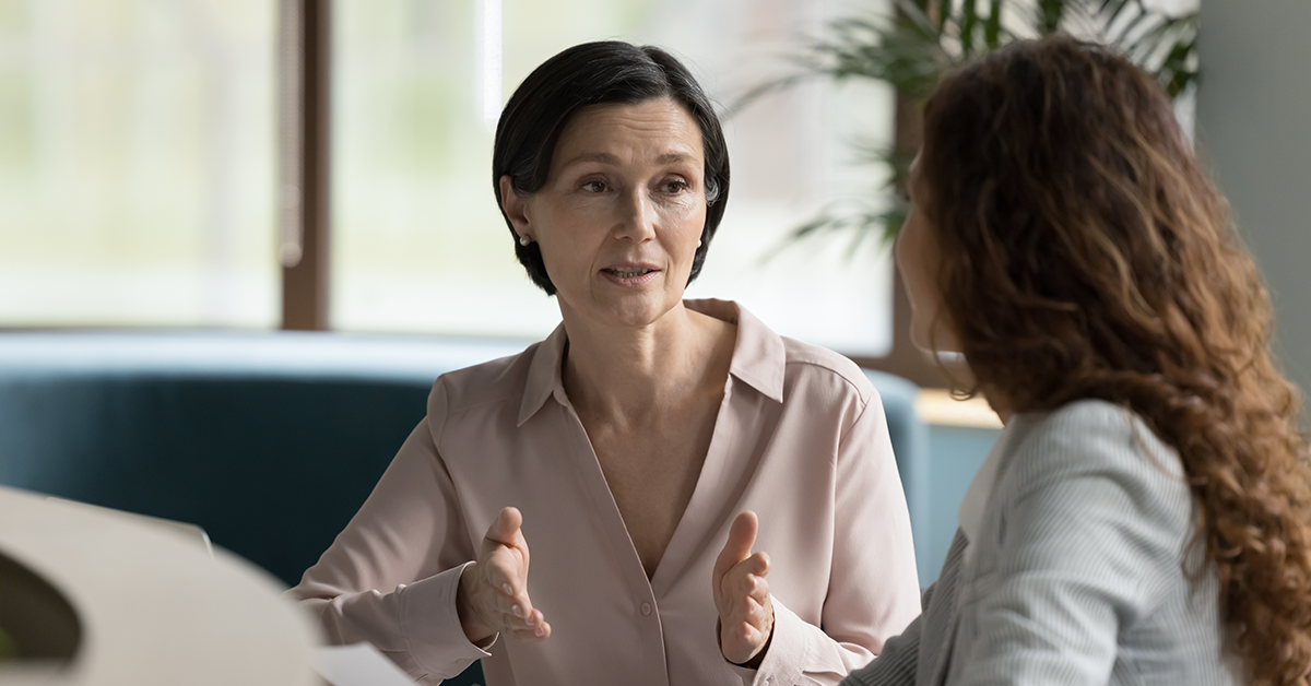 Manager talking to younger female employee at office 
