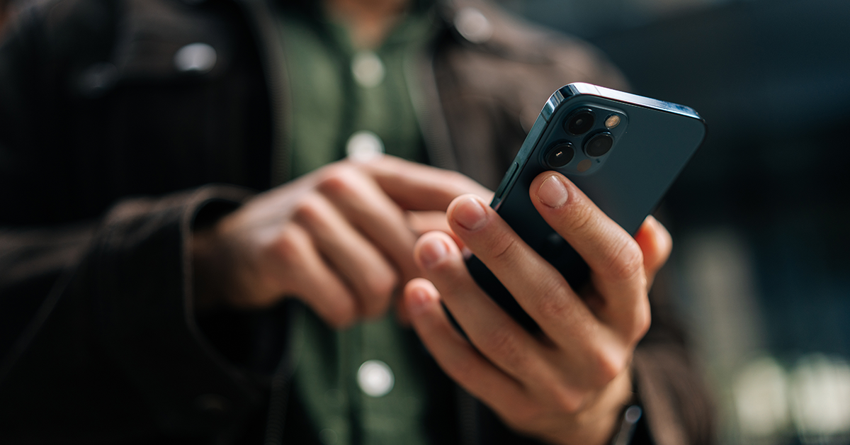 Close-up of hands holding and using smartphone