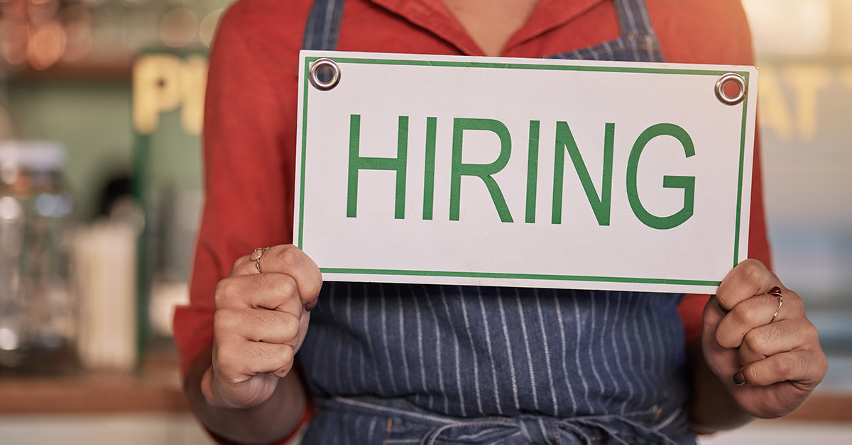 Hands holding a hiring sign for job vacancy