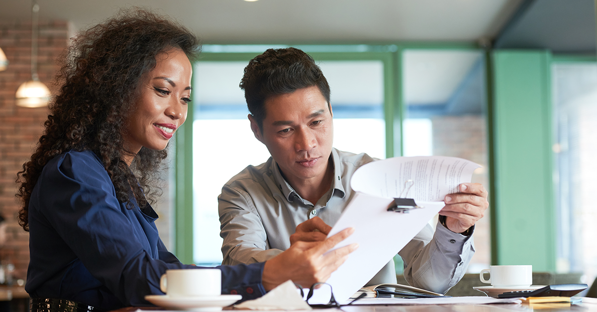 Man and woman at modern coffeehouse, working together on a project