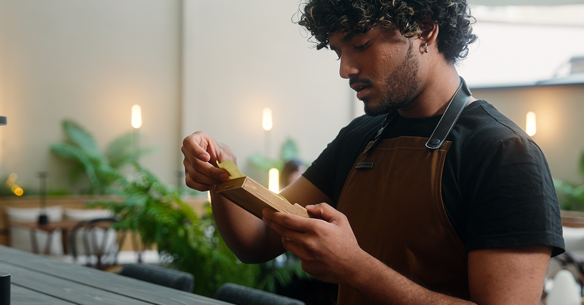 Male waiter reviewing tips at a restaurant