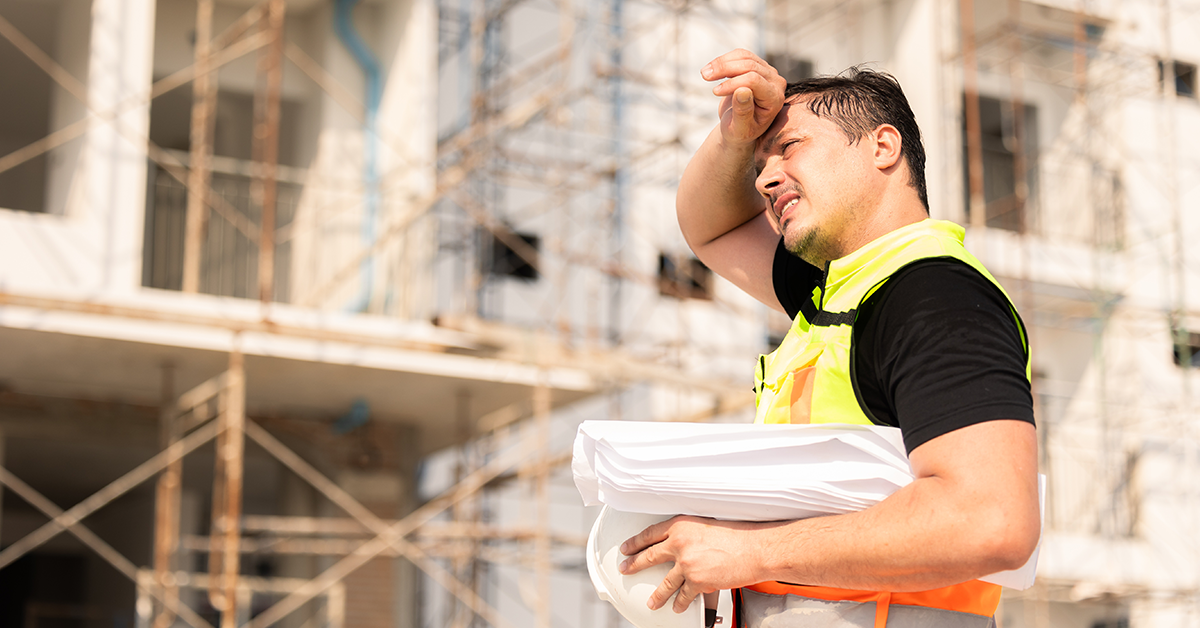 Tired, Sweating Construction Worker On Building Site Under Sunlight 