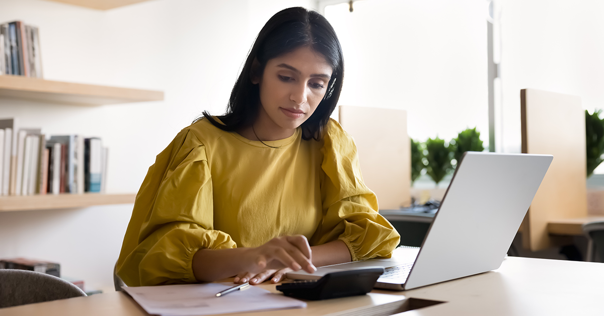 Focused businesswoman calculating budget, counting income, planning expenses.