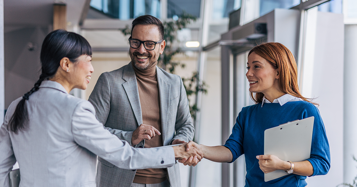 Woman shaking hands with employer, smiling 