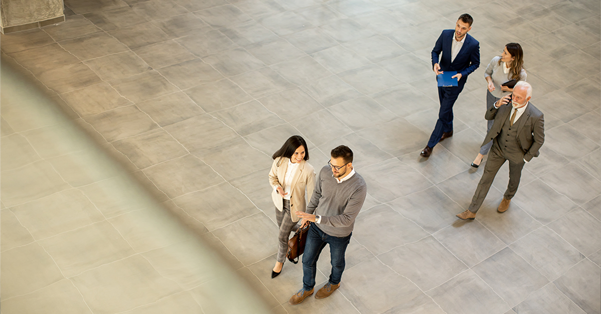 A group of young and senior business people are walking in an office hallway, in an aerial viewpoint