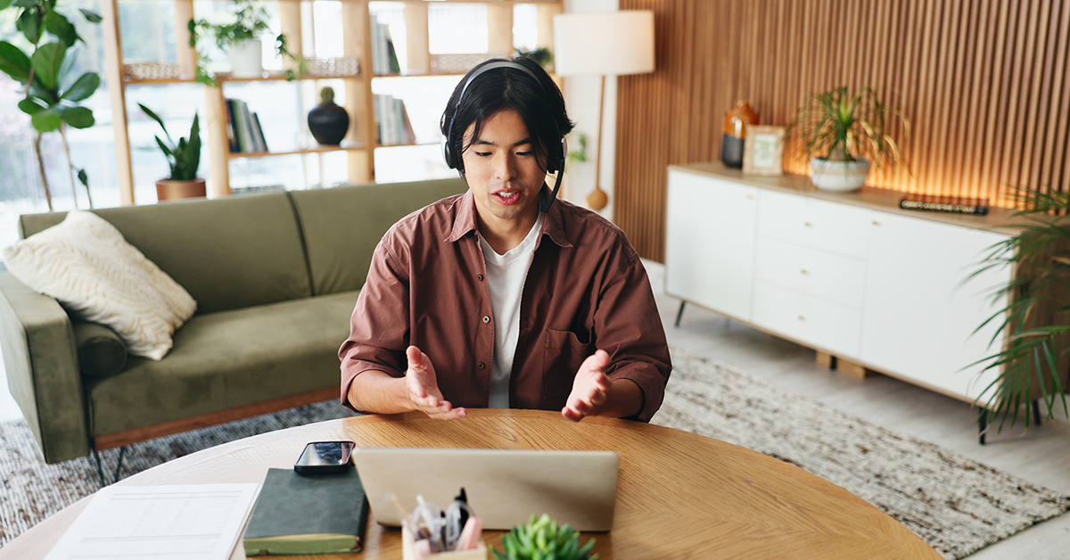 Remote worker, on video call, talking on headset at home