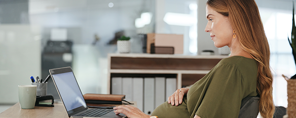 Pregnant business woman typing