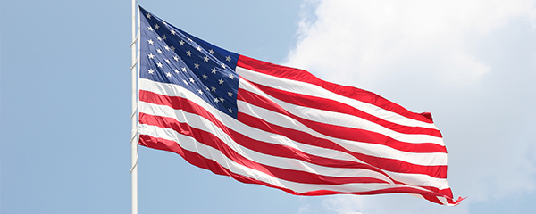 American Flag waving against cloudy sky