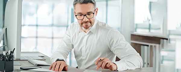 Businessman using a calculator and computer. Working on budget. 