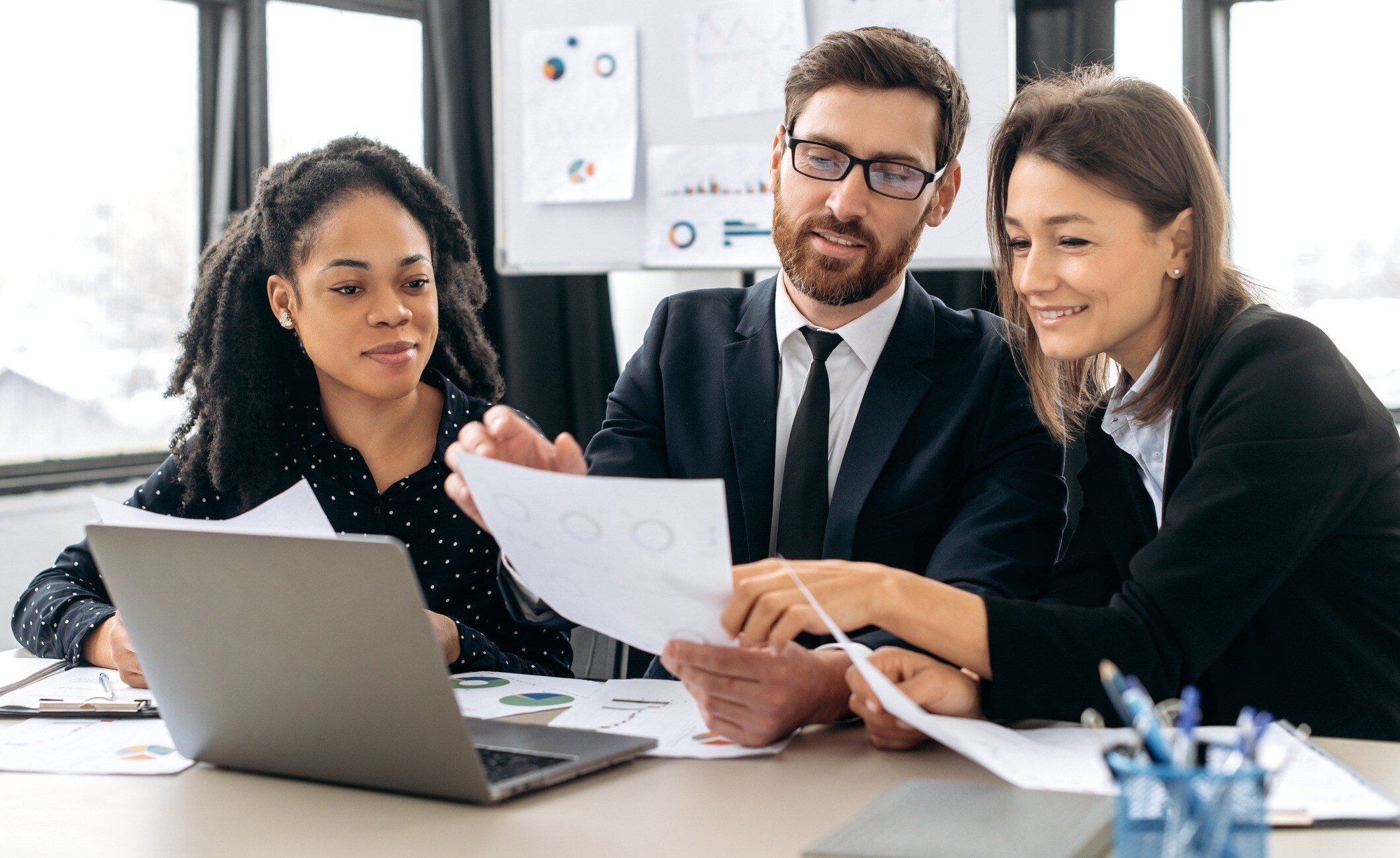 Three people look at a document.