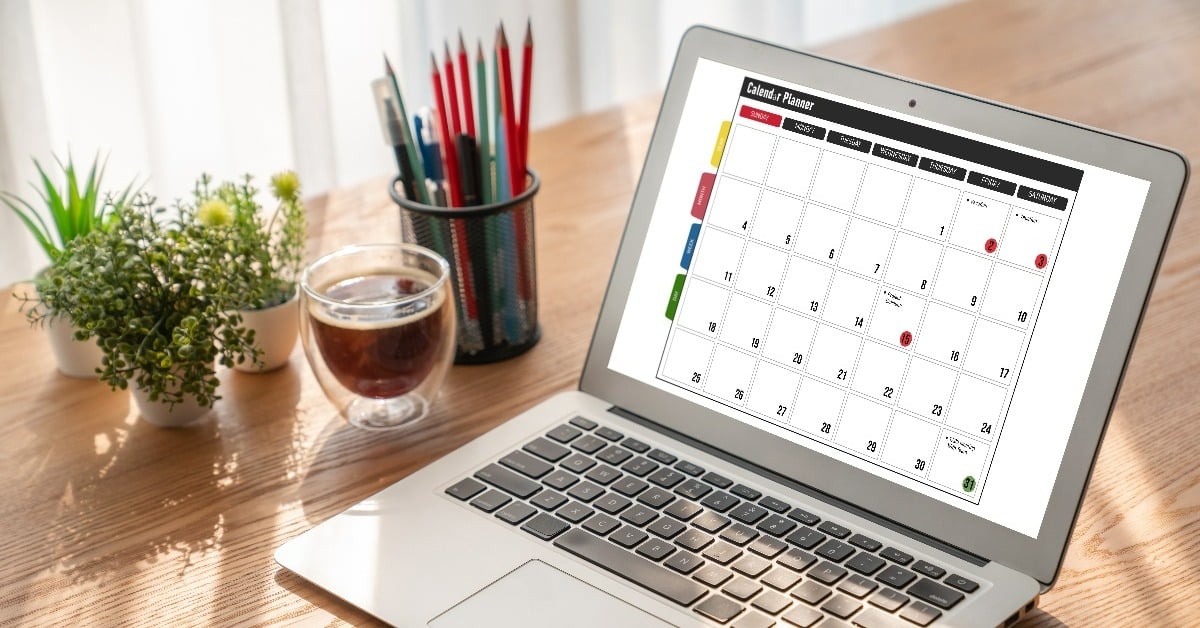 Calendar displaying on a laptop, sitting open on a desk