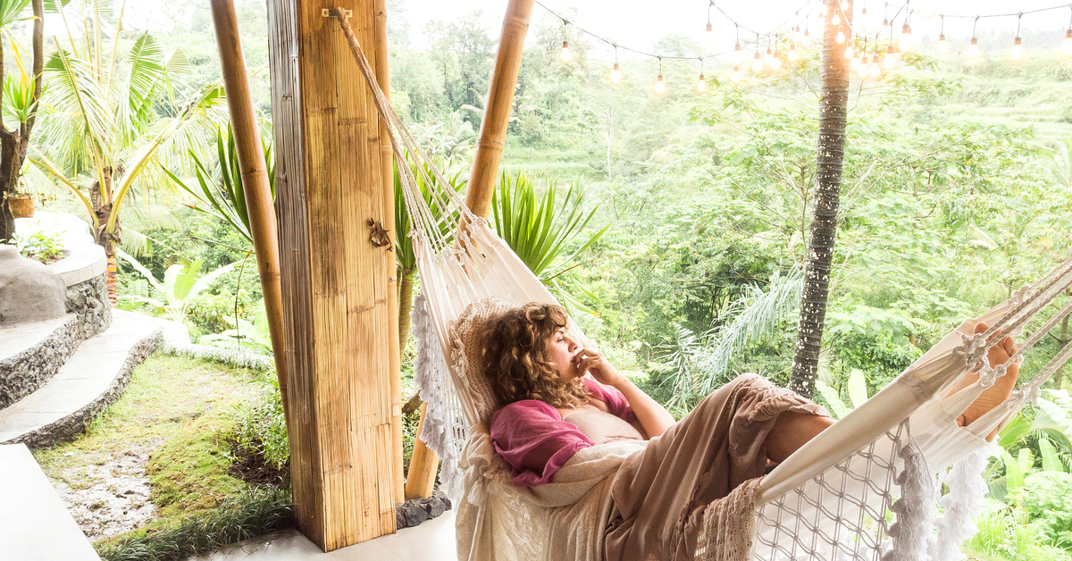 A woman contemplates while laying in a hammock