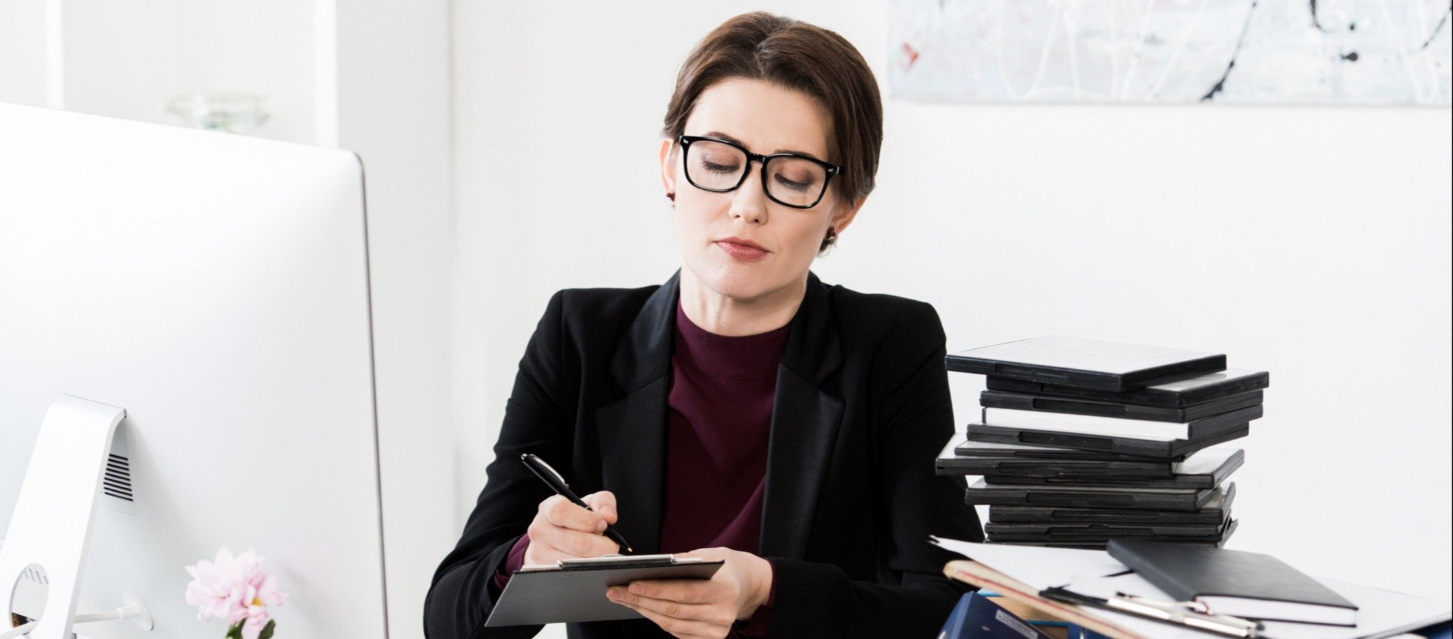 A woman writing on a clipboard.