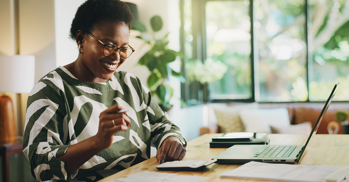 Female employee working with calculator, documents, and bills