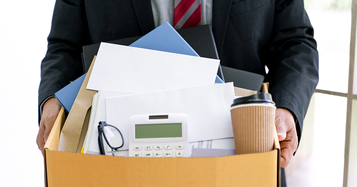 Man holding box of office supplies after layoff