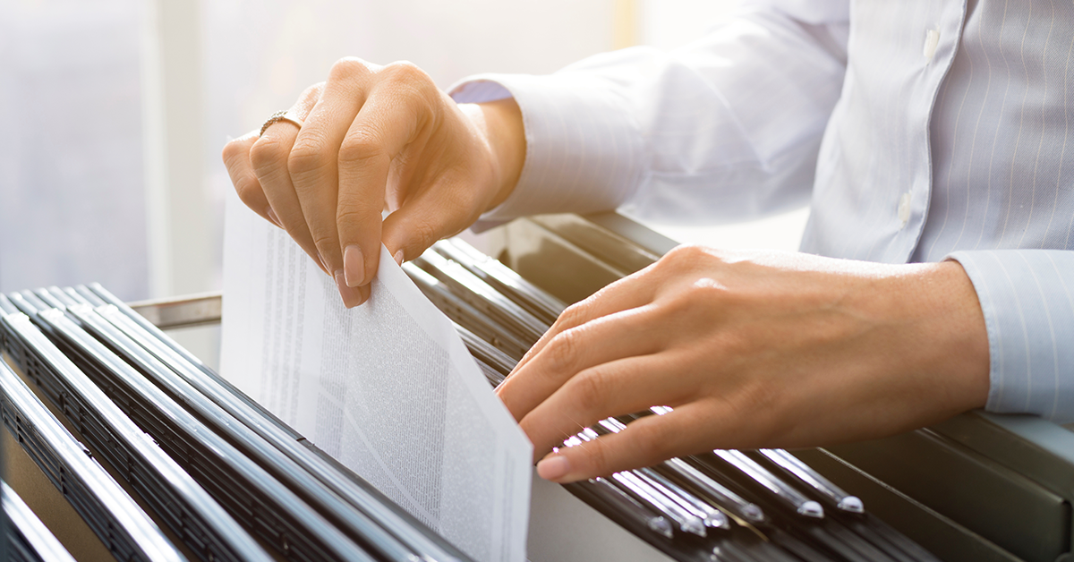 Office clerk searching files in the filing cabinet 