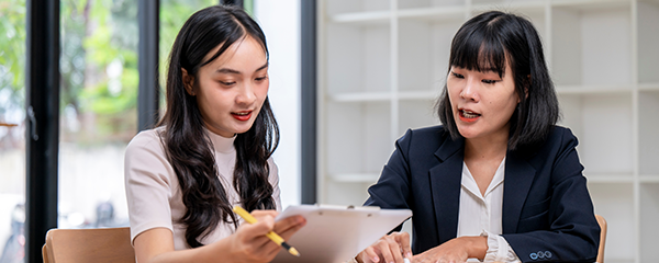 Two women sitting at a table, reviewing document